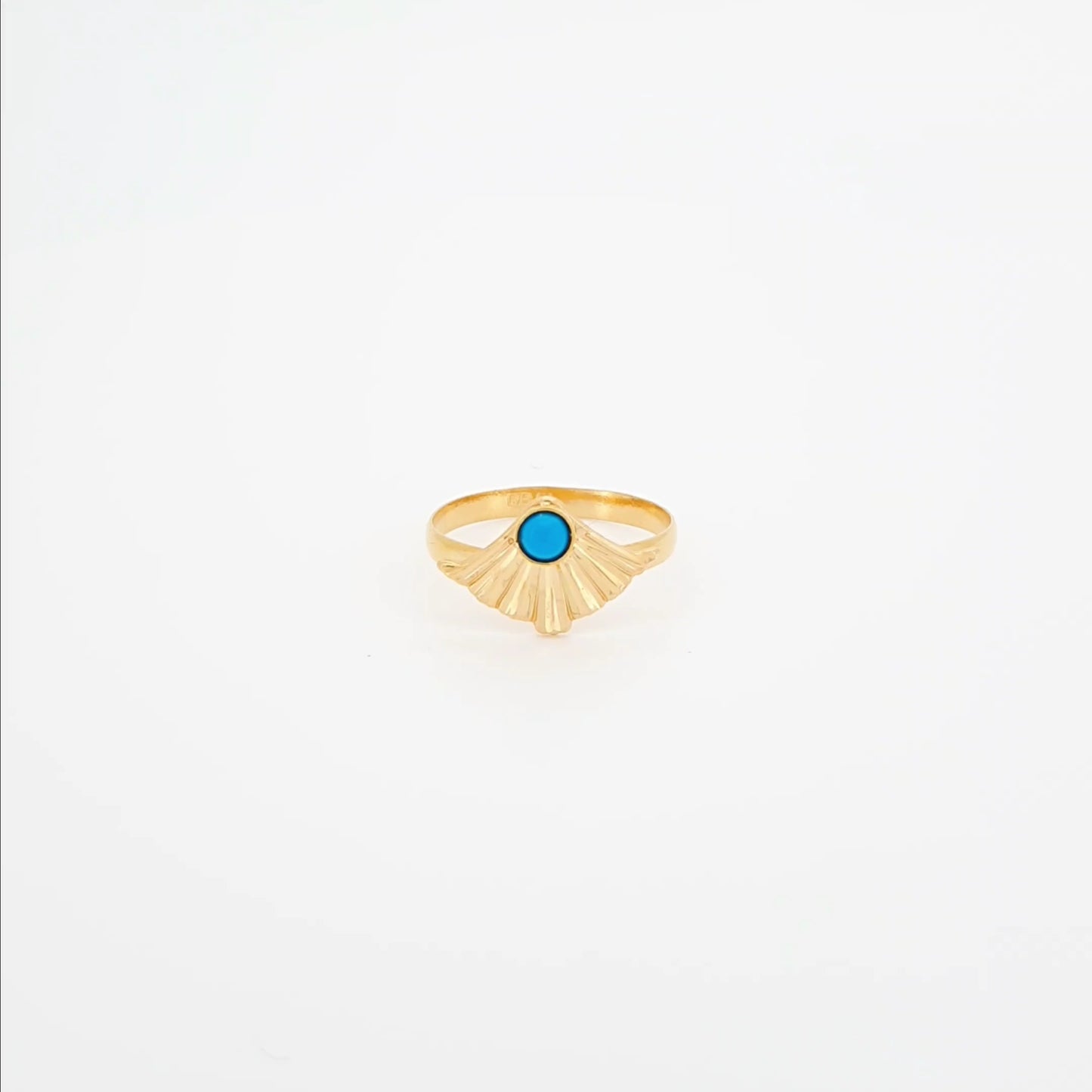 Gold ring with a blue gemstone on a white background